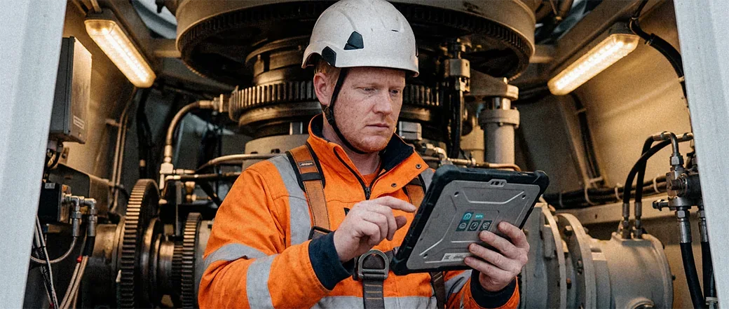 Windkrafttechniker prüft Anlagendaten auf einem robusten Tablet